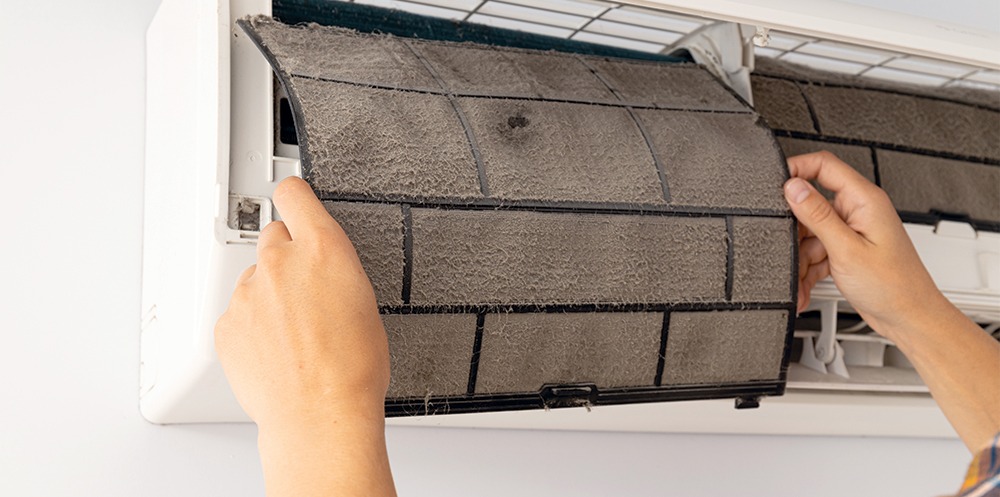 Nettoyage du filtre d'une thermopompe murale encrassée.