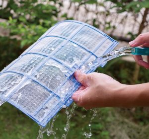 Rinçage d'un filtre de thermopompe à l'eau courante à l'extérieur