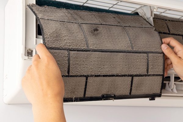 Nettoyage du filtre d'une thermopompe murale encrassée.